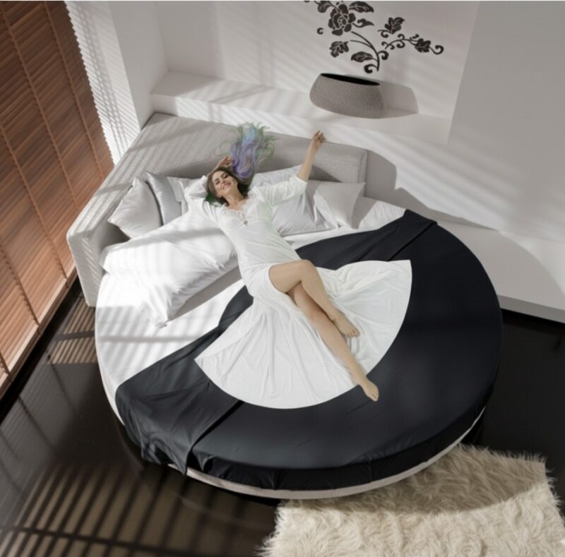 Letto rotondo angolare con copriletto elegante.