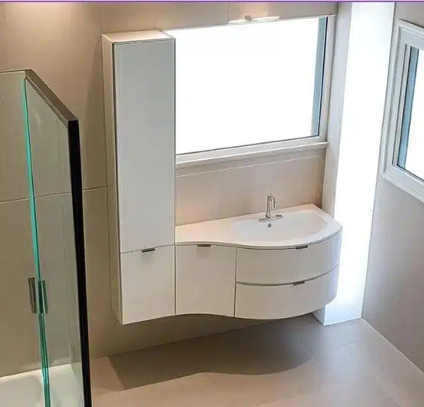 Mobile bagno curvo Compab B201 con colonna e lavabo integrato in mineralmarmo.