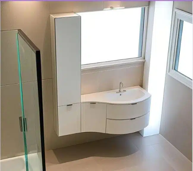 Mobile bagno curvo Compab B201 con colonna e lavabo integrato in mineralmarmo.