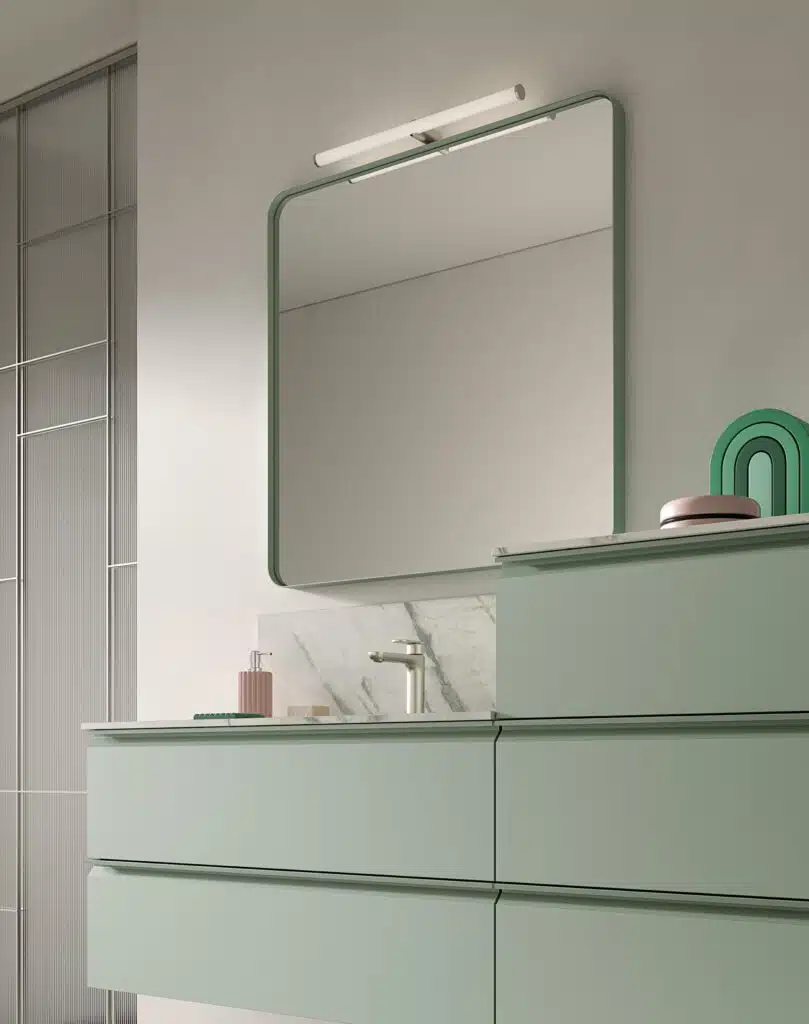 Ambientazione COMPAB BK14: bagno moderno con mobile sospeso, specchio retroilluminato e piastrelle effetto cemento. Design d'interni ricercato.