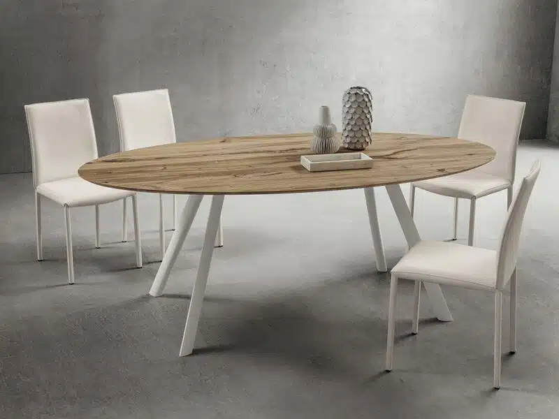 Tavolo ovale moderno in rovere antico con gambe bianche e sedie, design elegante.