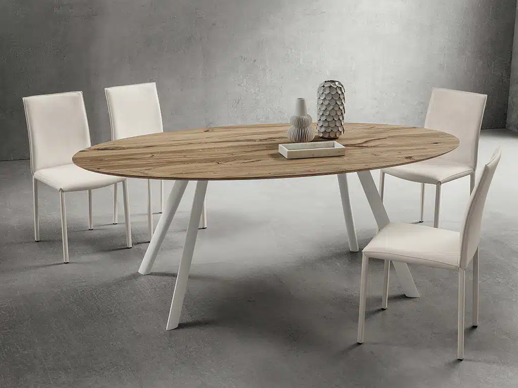 Tavolo ovale moderno in rovere antico con gambe bianche e sedie, design elegante.