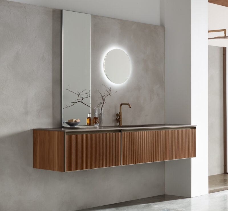 Scopri il Mobile Bagno Arcom Shape 10, il sistema componibile di design in finitura Greca Noce e Laminam Fokos Terra. Qualità Arcom e progetto 3D gratuito.