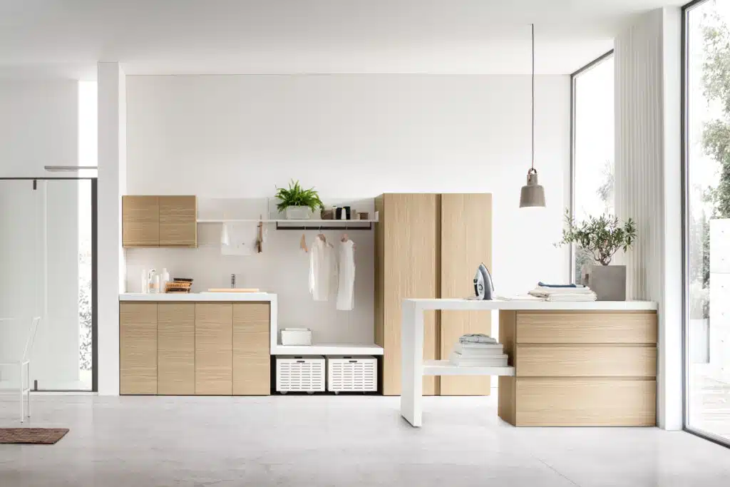 Arredo lavanderia funzionale I-WASH 01 di ARCOM con penisola operativa e finitura Rovere Natura.
