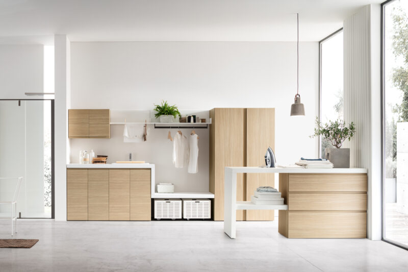 Arredo lavanderia funzionale I-WASH 01 di ARCOM con penisola operativa e finitura Rovere Natura.