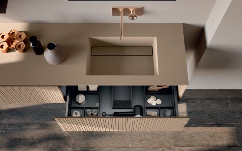 Arredo bagno di design con frontali cannettati verticali, lavabo integrato TRIP e pensile a giorno in finitura legno a contrasto.
