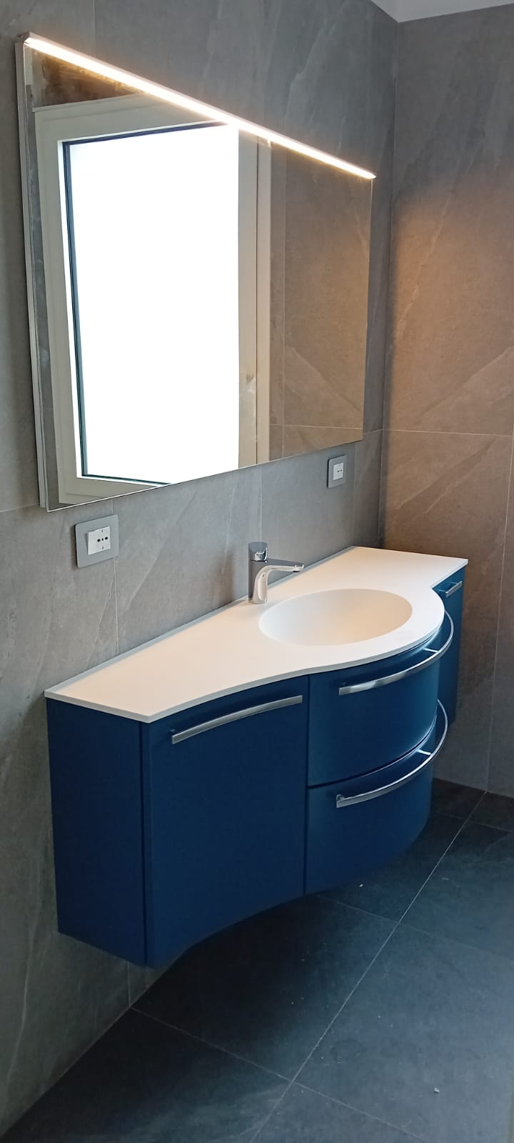 Dettaglio del lavabo integrato nel top del mobile bagno curvo Compab, finitura laccato lucido.