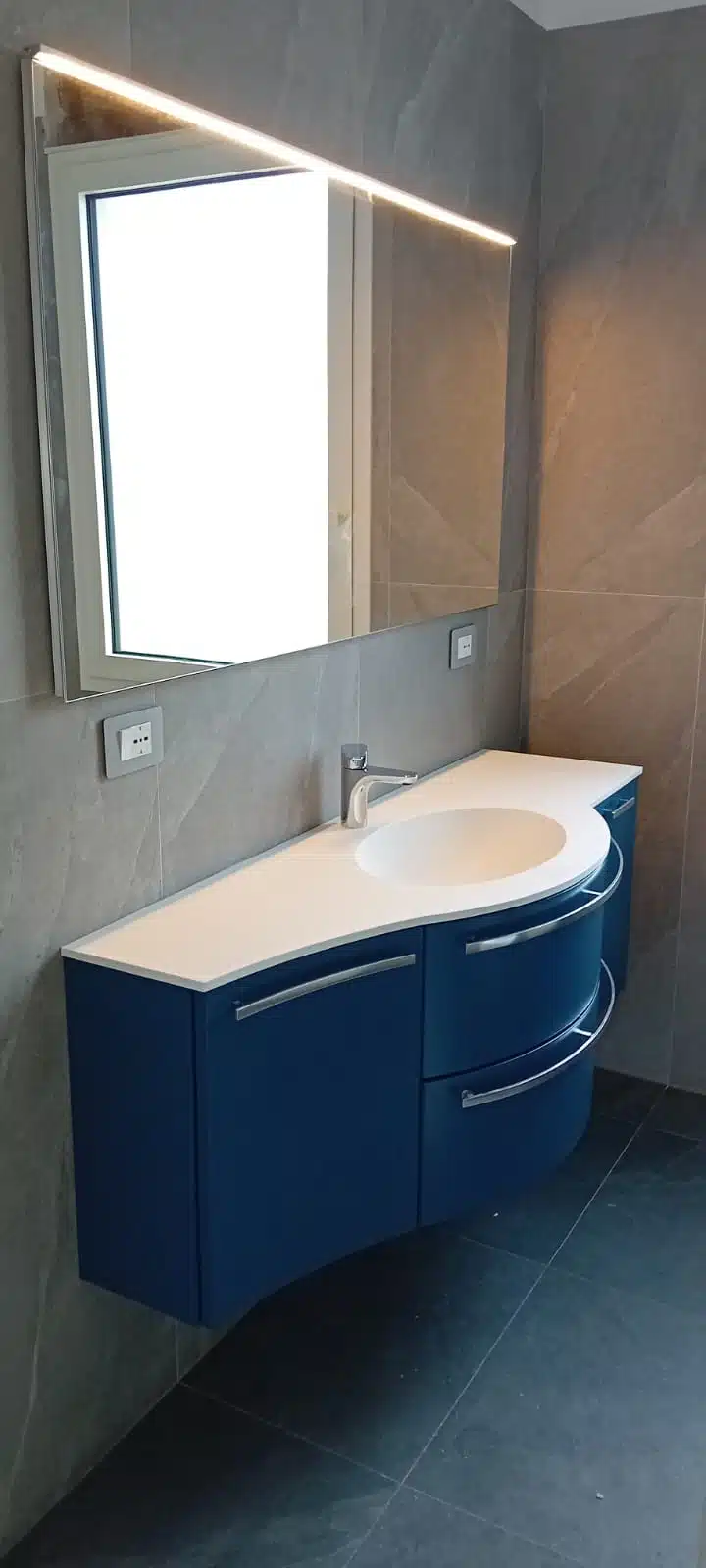 Dettaglio del lavabo integrato nel top del mobile bagno curvo Compab, finitura laccato lucido.
